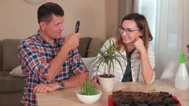 Mann und Frau posieren Tisch Mann hält Lupe, eine Frau Brille — Stockvideo
