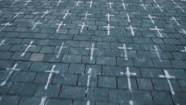 Kamerafahrt auf einem steinernen Bürgersteig. Die Symbole der Kreuze sind gezeichnet. — Stockvideo