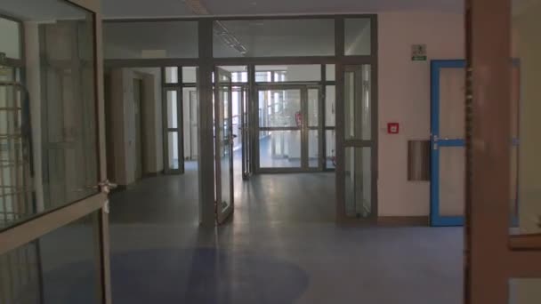Kamerarörelse längs glaskorridoren byggnad Utbytesdörrar — Stockvideo