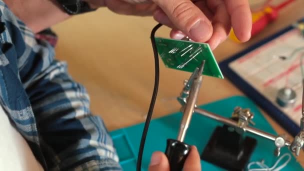 Fijne motoriek docenten hand soldeer het detail op elektronisch bord. — Stockvideo