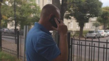 Adam şu an telefonda konuşuyor. Adımlarını atar, kapıyı kapatır..