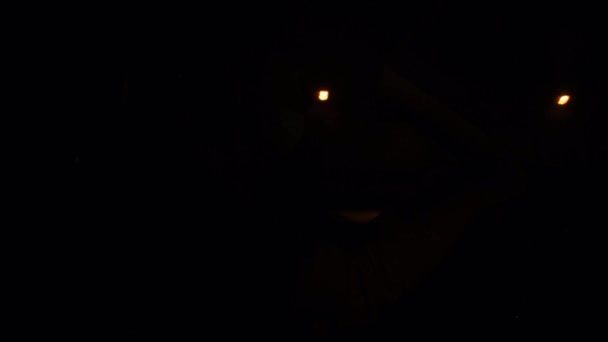 仮面の男が闇のトンネルから光に車を追い出す。ハンドルを握ってる. — ストック動画
