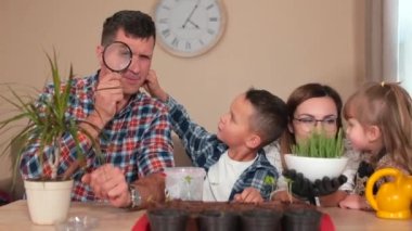 Aile, toprağa ekin ekmeye hazırlanıyor. Kızının bitkilerini gösteriyor.,