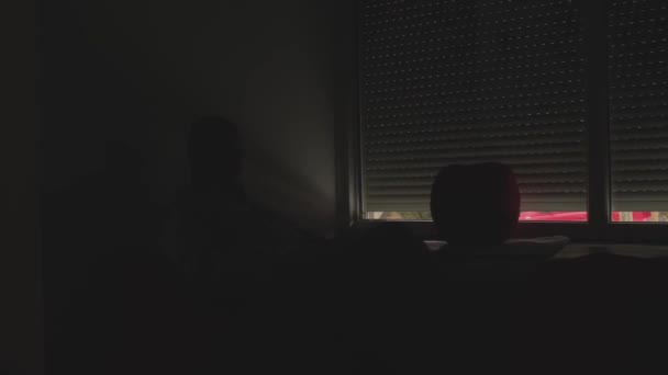 Mannen sitter i säcken stol. Öppnar persienner i fönstret. Arbetsdagens början. — Stockvideo