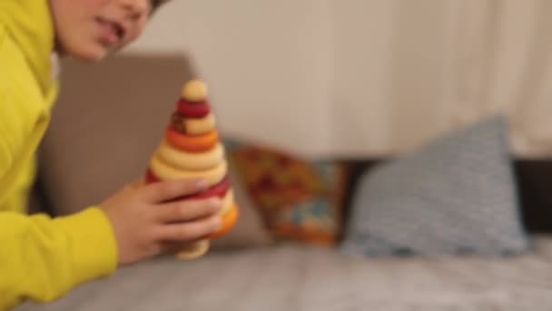 Ręka przechodzi dziecko zabawki. Rozkłada piramidę kawałek po kawałku rękami.. — Wideo stockowe