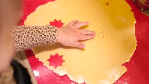 Kleine meisjes hand maakt deeg. Ze maakt stukken voor het bakken op de tafel — Stockvideo