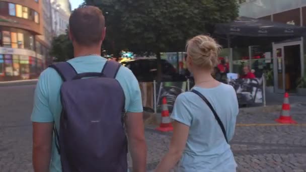 A kamerás férfi és nő körforgása a város utcáin. — Stock videók