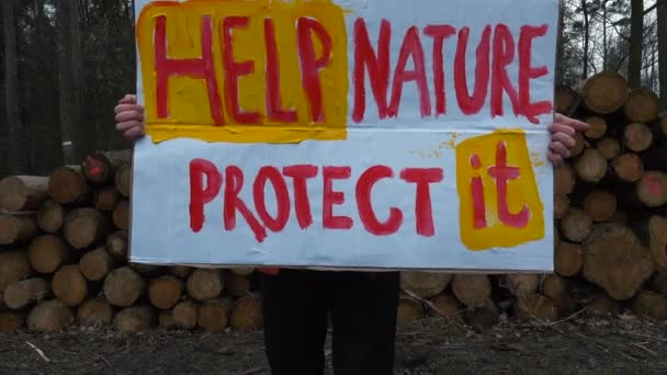 Male worker holds poster inscription help nature protect it forest conservation — Stock Video