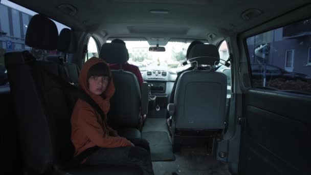 Vehículo comienza a moverse hombre se sienta en el asiento del conductor, comienza a conducir con su familia — Vídeos de Stock