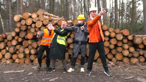 Arbeiter machen Selfies in der Nähe gestapelter Baumstämme. Sie fotografierten am Ende des Projekts. — Stockvideo