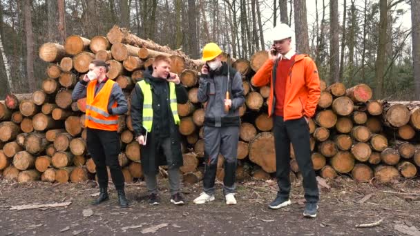 Pilařští dělníci používají telefony ve svých rukou. Zaměření na obrazovku — Stock video