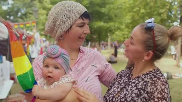 Família LGBT feliz com bebê no festival Pride contra homofobia e transfobia — Vídeo de Stock