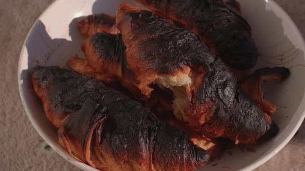 Croissant bruciato in piatto. Lo chef ha commesso un errore di temperatura del tempo di cottura. — Video Stock