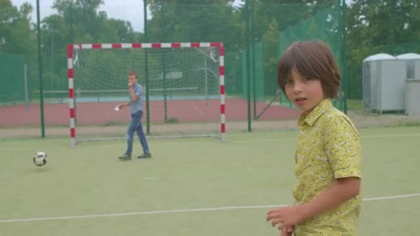 Adolescente gira alrededor del campo de fútbol. Enfoque la atención de la cámara durante bola juego — Vídeo de stock