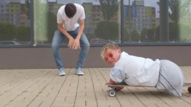 Engelli kadın kaldırım kaykayına biniyor. Harekete geçerek yerden yükseliyor.