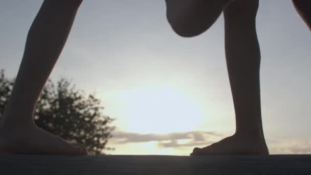 シルエットの空に対する足。子供たちは日没時に足を動かす. — ストック動画