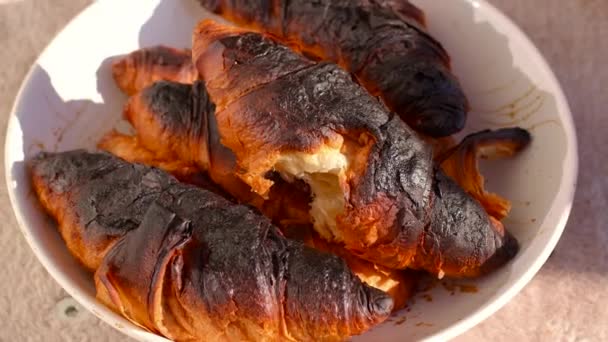 Croissants queimados no prato. Erro de cozimento, temperatura elevada do forno. — Vídeo de Stock