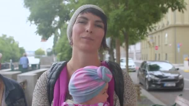 Mulher carregando criança na rua da cidade. Transporte bebê, parentalidade natural. — Vídeo de Stock