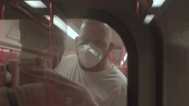 客車の乗客列車。マスクをした男性客ガラス越しの撮影 — ストック動画