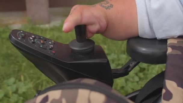 Minder valide persoon vinger drukt rolstoel joystick beweegt weg stad — Stockvideo