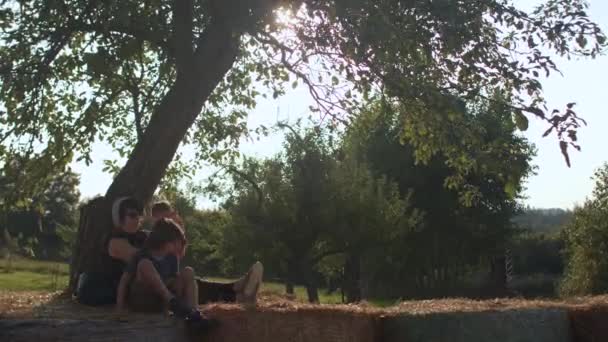 Los turistas descansan sobre fardos de heno. Agroturismo en las zonas agrícolas. — Vídeo de stock