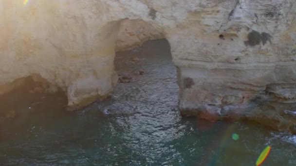Arco de piedra en agua de mar. La luz del sol es un punto culminante. Rugosidad natural. — Vídeo de stock