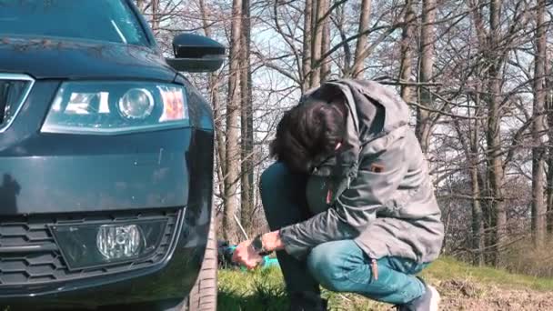 一个人正在电话里修理汽车，他被困在破车上. — 图库视频影像
