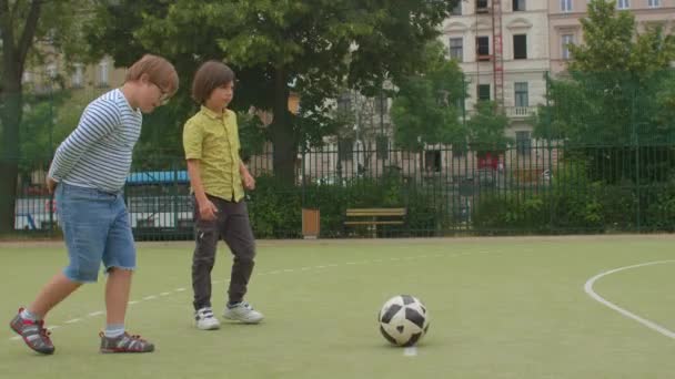 Tonåringen slår till på fotbollsplanen. Han drar upp byxor med händerna. — Stockvideo