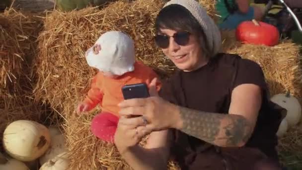 Mamá con un niño se toma una selfie en el campo, usando el teléfono para tomar una foto — Vídeos de Stock