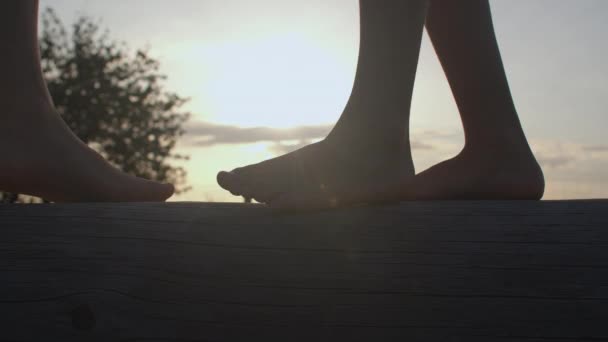 Sylwetka dzieci bosych stóp o zachodzie słońca. Korzyści z utwardzania ciała. — Wideo stockowe