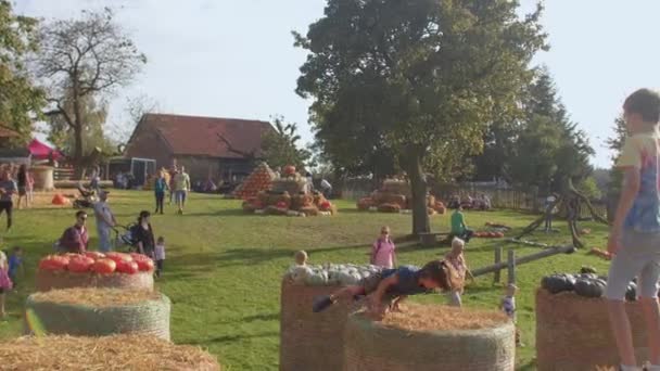 Kinder springen beim Erntedankfest auf Heuballen. — Stockvideo