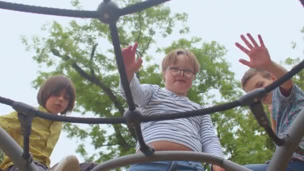 少年たちはカメラに手を振る。眼鏡の子供はダウン症候群を持っています. — ストック動画