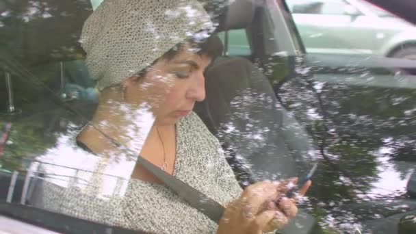 La mujer usa el teléfono en las manos en el auto. Disparo a través de vidrio, reflejo de destello de lente. — Vídeo de stock