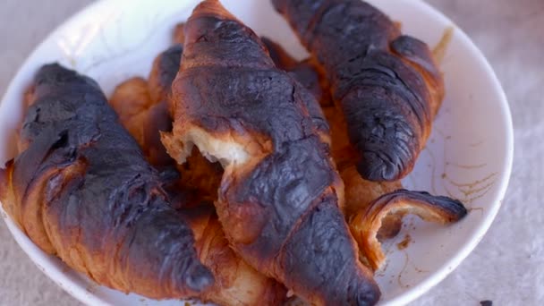 Error de cocción en casa. Croissant quemado corteza negra prohibición de comer carcinógenos. — Vídeo de stock