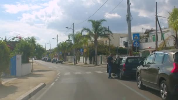 Viaja a Pulia. Calle de la ciudad con estacionamiento a la derecha. Palmeras. — Vídeo de stock