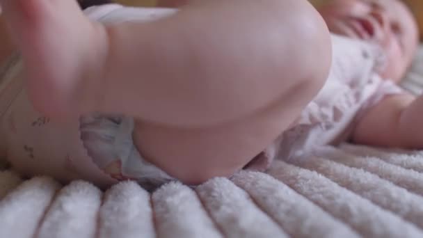 Un bambino piccolo che piange sdraiato sul divano. Si muove le gambe, mostra disagio. — Video Stock