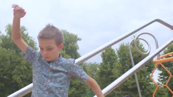 Teenager rollt mit einer Rutsche auf einem Rohr in einem Stadtpark. Es wird mit der Hand gehalten. — Stockvideo