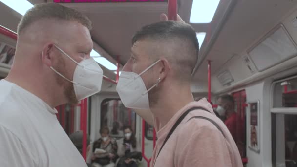 Dva gayové v lékařských respirátorech jezdí v podzemí. — Stock video