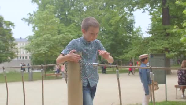 De beweging van de camera op de speelplaats. De tiener beweegt op de touwen. — Stockvideo