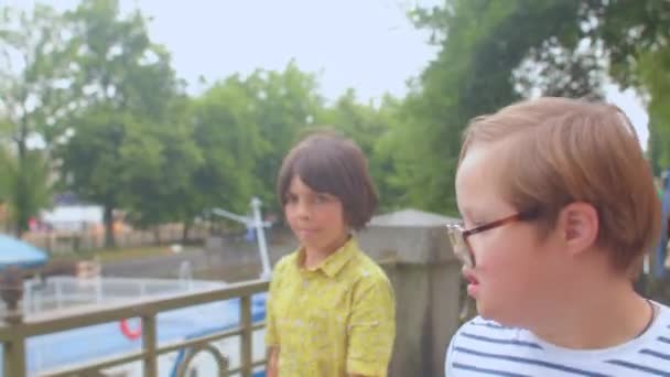 Anak laki-laki Down sindrom memindahkan keluarga di sekitar kota. Dia menggunakan kacamata meningkatkan penglihatannya.. — Stok Video