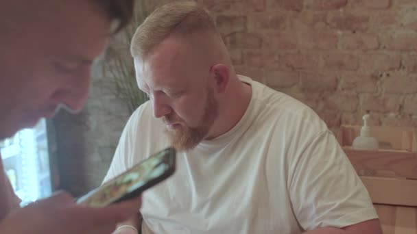 Процесс создания поста для социальных сетей. Блогер питания в городском кафе. — стоковое видео