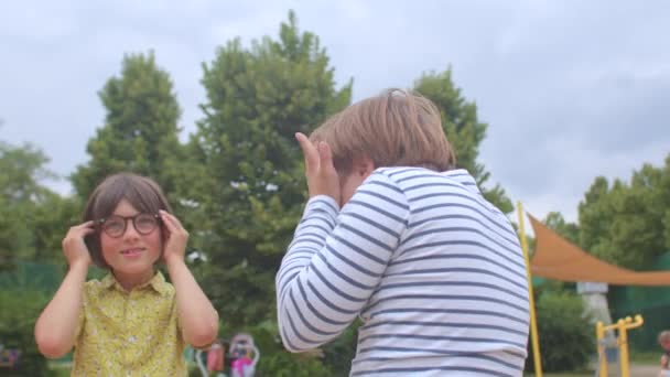Fiú tesz szemüveg jön fel néz ki kamera Kommunikáció barátja Down-szindróma — Stock videók