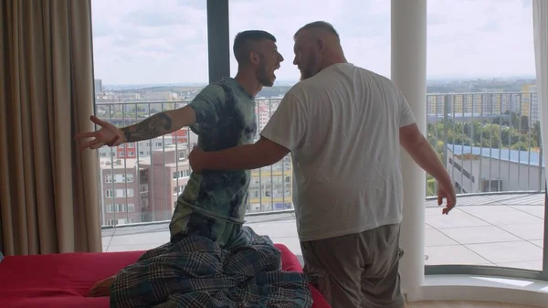 La relación de una pareja gay. Dos hombres se divierten en el dormitorio, bailando —  Fotos de Stock