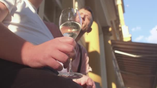Die Hand des Mannes hält ein Glas Getränk. Er sieht sonnig aus. Treffen nach langer Trennung — Stockvideo