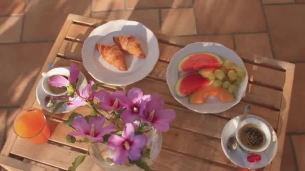 Легкий завтрак включает фрукты, круассаны и напитки на столе в отеле. — стоковое видео