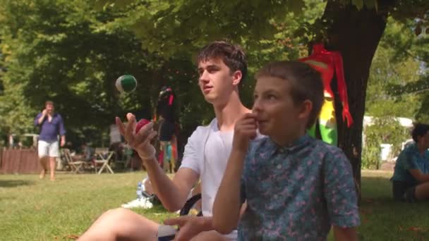 Teenager trains hands juggling, ball control teacher trains in the background. — Stock Video