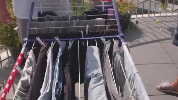 Drogen van kleding op balkon onder de zon man hangt doek. — Stockvideo