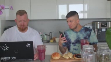 İki eşcinsel adam meyve suyu içiyor, kahvaltıda ev mutfağında. Vitamin diyeti