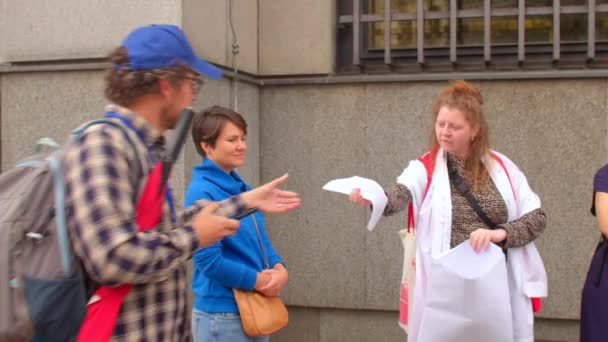 Passer tar broschyr händer. Utbyta information vid protesten, tryckta medier — Stockvideo