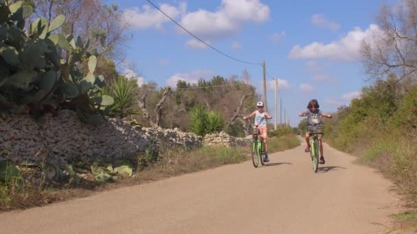 Дети ездят на велосипедах по южным деревням. — стоковое видео